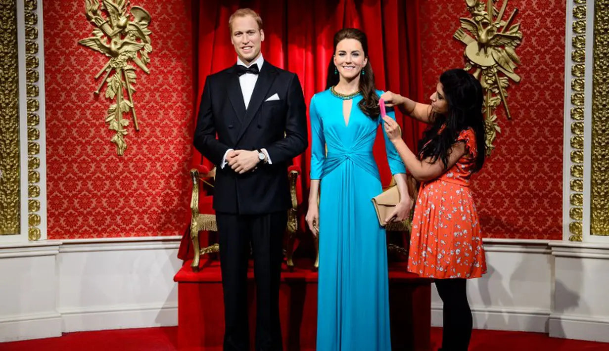 Seorang pekerja Madame Tussauds tampak merapikan penampilan baru patung lilin Pangeran Williams dan Kate Middleton, London, Rabu (2/7/14). (AFP PHOTO/Leon Neal)