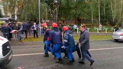Dalam gambar yang diambil dari video ini, karyawan darurat membawa yang terluka dari lokasi penembakan di Sekolah No. 88, Izhevsk, Rusia, Senin (26/9/2022). Aksi pria bersenjata tersebut dilakukan di sebuah kota sekitar 960 kilometer (596 mil) timur Moskow di wilayah Udmurtia. (Izhlife.ru via AP)