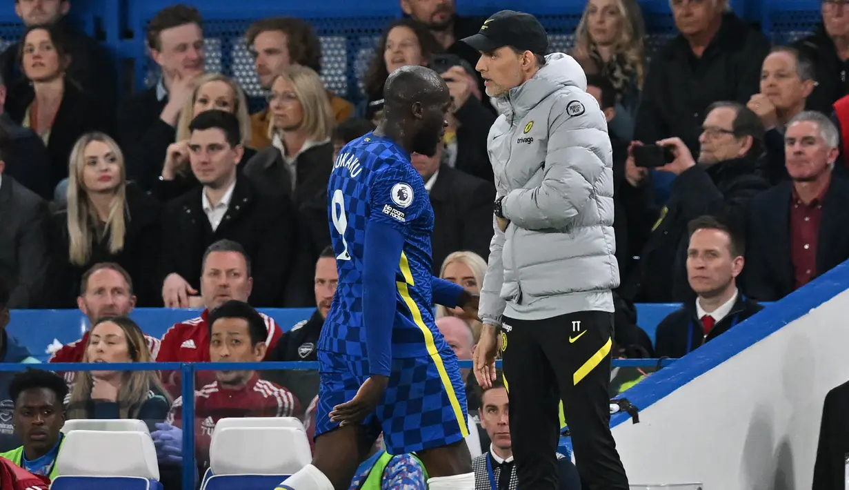 Romelu Lukaku berjalan keluar lapangan melewati Thomas Tuchel dalam pertandingan lanjutan Liga Inggris 2021/2022 antara Chelsea melawan Arsenal di Stamford Bridge 20 April 2022. (AFP/Glyn Kirk)