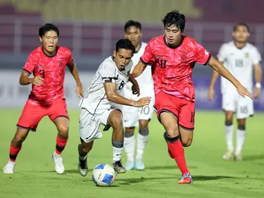 Pemain Timnas Indonesia U-23, Muhammad Rayhan Hannan (tengah) berebut bola dengan Jeong Jaesang (Korea Selatan) pada laga Kualifikasi Piala Asia U-23 2026 Grup J yang digelar di Stadion Gelora Deltra, Sidoarjo, Jawa Timur, Selasa (9/9/2025) malam WIB. (Bola.com/Abdul Aziz)