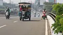 Sejumlah warga menaiki bak terbuka motor roda tiga menuju Kebun Binatang Ragunan di kawasan Jakarta, Minggu (9/6/2019). Selain melanggar aturan lalu lintas, perilaku tersebut juga sangat membahayakan keselamatan penumpang. (Liputan6.com/Herman Zakharia)