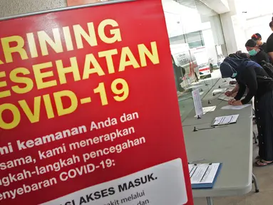 Pengunjung mengisi formulir pernyataan kesehatan sebelum memasuki Rumah Sakit Siloam, Jakarta, Sabtu (7/3/2020). RS Siloam menyediakan fasilitas tenda isolasi sementara, ruangan dekontaminasi dan pengecekan suhu tubuh guna mengantisipasi penyebaran virus corona. (Liputan6.com/Herman Zakharia)