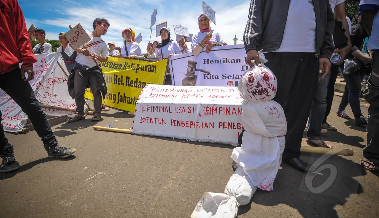 Massa membawa boneka pocong dalam aksi Karnaval Rakyat Lawan Korupsi dari patung kuda menuju Istana Negara, Jakarta, Rabu (8/4/2015). Aksi tersebut menuntut untuk menghentikan kriminalisasi terhadap KPK. (Liputan6.com/Faizal Fanani)