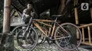 Kharis (25) mengecek sepeda bambu Jatnika di Workshop Perajin Bambu Indonesia, Cibinong, Bogor, Jawa Barat, Minggu (5/7/2020). Saat ini, Kharis meneruskan produksi sepeda bambu yang dicetus sejak 2010 oleh ayahnya, Jatnika (67). (merdeka.com/Iqbal S. Nugroho)