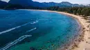 Di pantai ini pengunjung juga dapat menikmati suasana pantai yang asri. Tampak dalam foto, pemandangan udara menunjukkan orang-orang saat berkumpul menikmati masa libur panjang Idulfitri di area olahraga air, Pantai Lhoknga, Aceh, pada Kamis 26 Maret 2026. (Chaideer MAHYUDDIN/AFP)