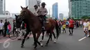 Petugas kepolisian menunggang kuda saat melakukan pengamanan di Car free day, Jakarta, Minggu (21/02). Polisi berkuda ini menjadi perhatian masyarakat yang sedang menikmati Car Free Day (CFD). (Liputan6.com/Helmi Afandi)
