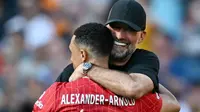 Pelatih Liverpool, Jurgen Klopp, berpelukan dengan Trent Alexander-Arnold saat seremoni perpisahan setelah laga melawan Wolverhampton Wanderers pada pekan terakhir Liga Inggris di Stadion Anfield, Minggu (19/05/2024). (AFP/Paul Ellis)