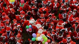Anak-anak sekolah India mengenakan kostum Santa Claus berpose saat mereka mengambil bagian dalam acara Natal di sebuah sekolah di Chennai, (5/12). Natal adalah hari raya umat Kristen yang diperingati setiap tanggal 25 Desember. (AFP Photo/Arun Sankar)