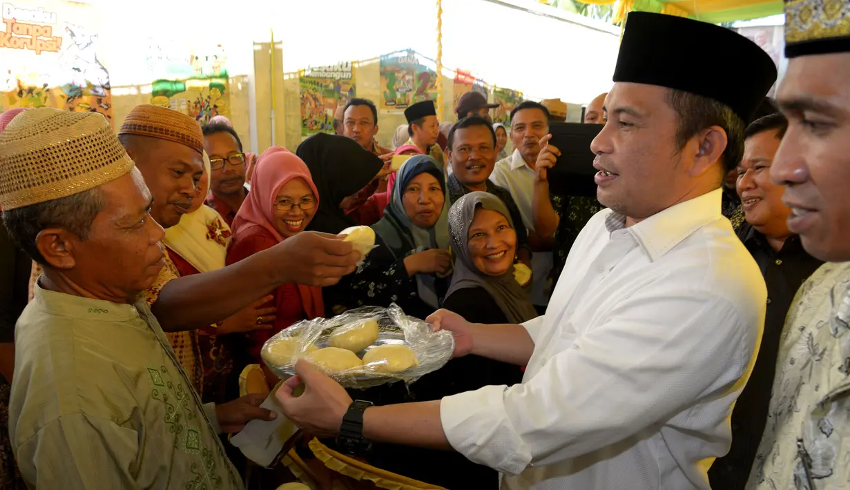 Menteri Desa, PDT dan Transmigrasi Marwan Jafar berbagi kue dengan warga saat melakukan kunjungan kerja ke Desa Huntu Barat, Bulango Selatan, Bone Bolango, Gorontalo, Minggu (10/1/2016). (Foto; Wahyu Wening/Humas Kemendes)