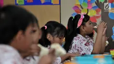 Siswi menyantap makanan tambahan saat program Penyediaan Makanan Tambahan Anak Sekolah (PMTAS) di SD Negeri 01 Tanjung Priok, Jakarta, Kamis (28/3). Pemprov DKI Jakarta menggelontorkan dana Rp 324 miliar untuk memenuhi gizi anak SDN di Jakarta dengan program PMTAS. (merdeka.com/Iqbal S. Nugroho)