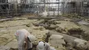 Para arkeolog menggali lantai Katedral Notre Dame setelah ditemukannya sarkofagus timah abad ke-14, di Paris (15/3/2022). Para arkeolog telah menemukan sarkofagus timah kuno bersama dengan potongan-potongan tirai. (AFP/Julien De Rosa)