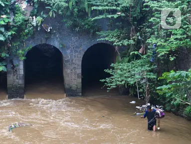 Warga berjalan di depan bangunan Jembatan Terowongan Tiga di kawasan Matraman, Jakarta, Minggu (12/6/2022). Jembatan Terowongan Tiga yang ditetapkan sebagai bangunan cagar budaya oleh Pemprov DKI Jakarta tersebut kondisinya terbengkalai dan kumuh. (Liputan6.com/Herman Zakharia)