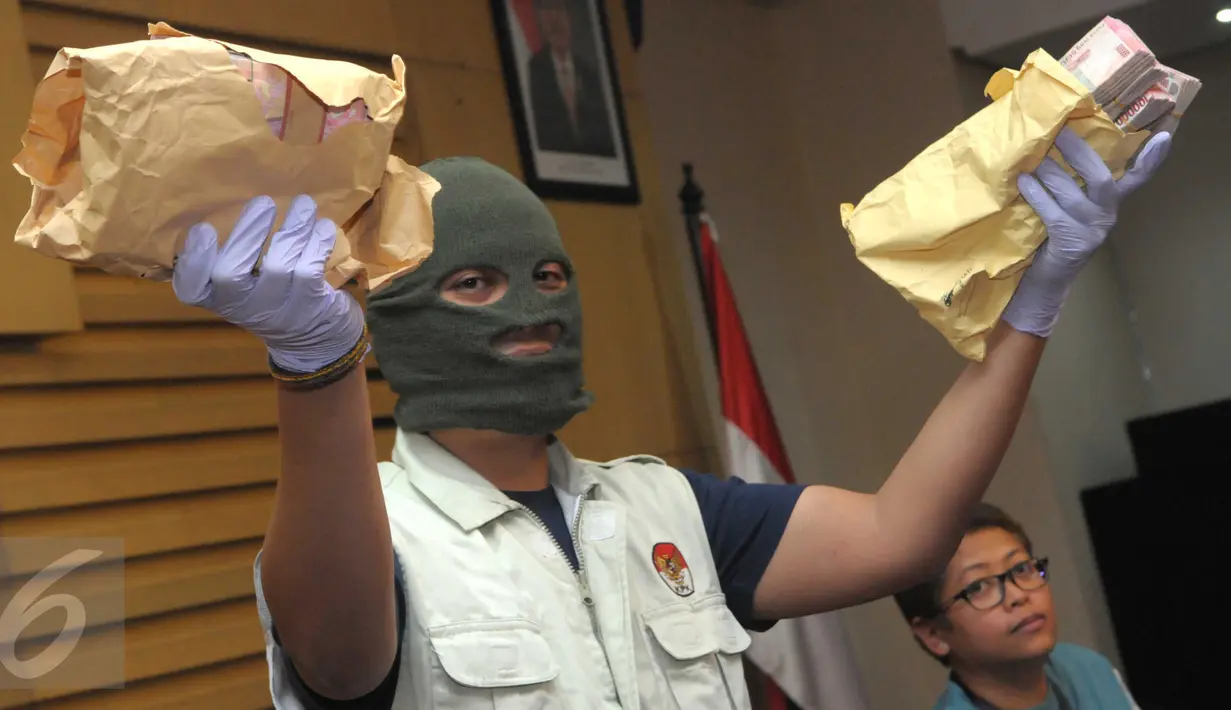 Petugas KPK saat memegang uang sitaan sebesar Rp150 juta sebagai barang bukti di Kantor KPK, Jakarta, (24/5/2016).KPK turut menyita uang Rp 650 juta dalam operasi tangkap tangan (OTT) terhadap Ketua PN  Kepahiang, Janner Purba. (Liputan6.com/Helmi Afandi)