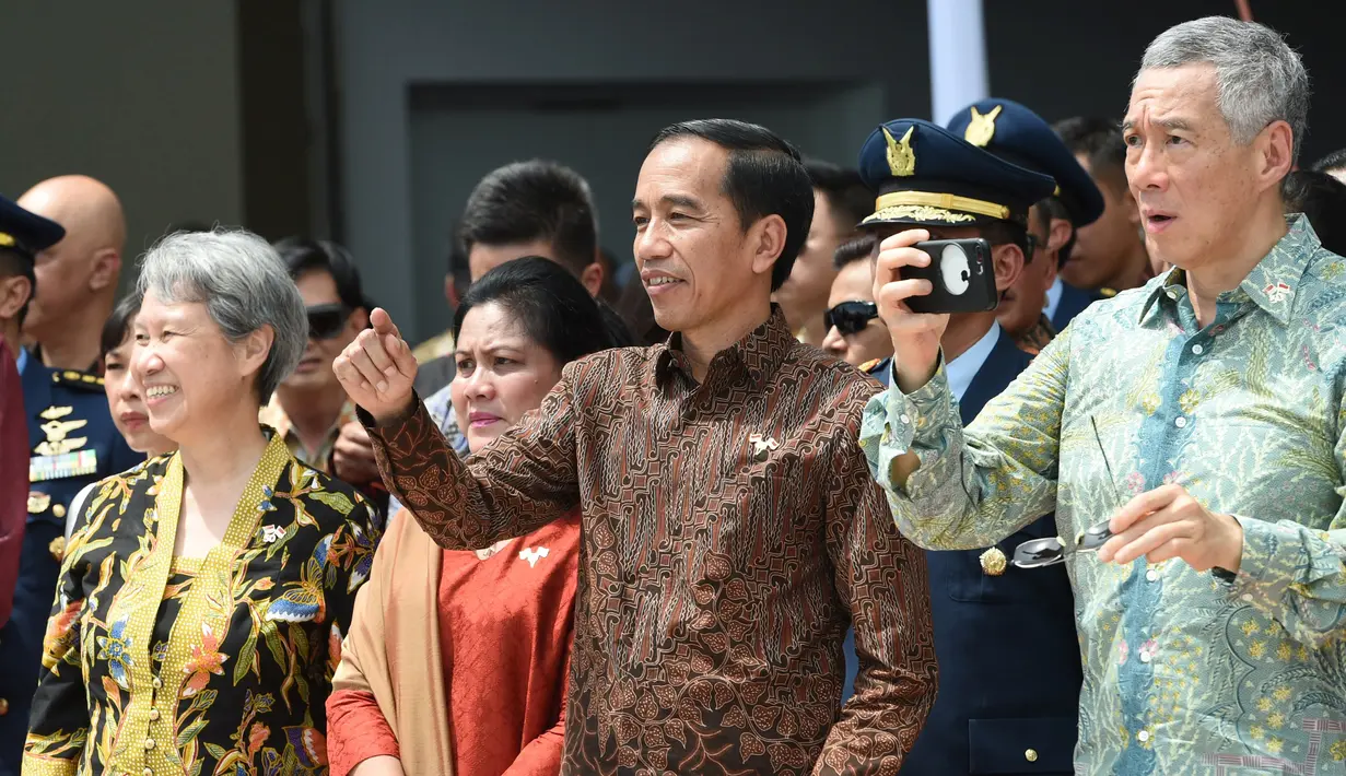 Presiden RI Joko Widodo didampingi Ibu Negara Iriana dan PM Singapura Lee Hsien Loong dan istrinya Ho Ching menyaksikan manuver F16 Angkatan Udara Singapura dan F16 TNI-AU di Marina Bay Cruise Center di Singapura, Kamis (7/9). (AFP Photo/Roslan Rahman)