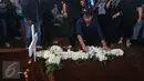 Penyanyi Delon meletakkan karangan bunga di atas makam Mike Mohede di TPU Tanah Kusir, Jakarta, Selasa (2/8). Sejumlah musisi dan selebriti ikut hadir untuk mengantar Mike Mohede ke peristirahatan terakhirnya. (Liputan6.com/Herman Zakharia)