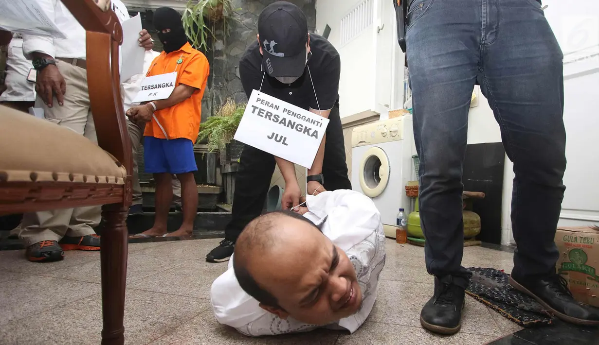 Tersangka melakukan adegan rekonstruksi pembunuhan pasutri di Benhil, Jakarta, Senin (9/10). 26 adegan dilakukan dalam rekonstruksi kasus yang menyebabkan tewasnya Zakaria Husni (57) dan istrinya Zakiya Husni (52). (Liputan6.com/Immanuel Antonius)