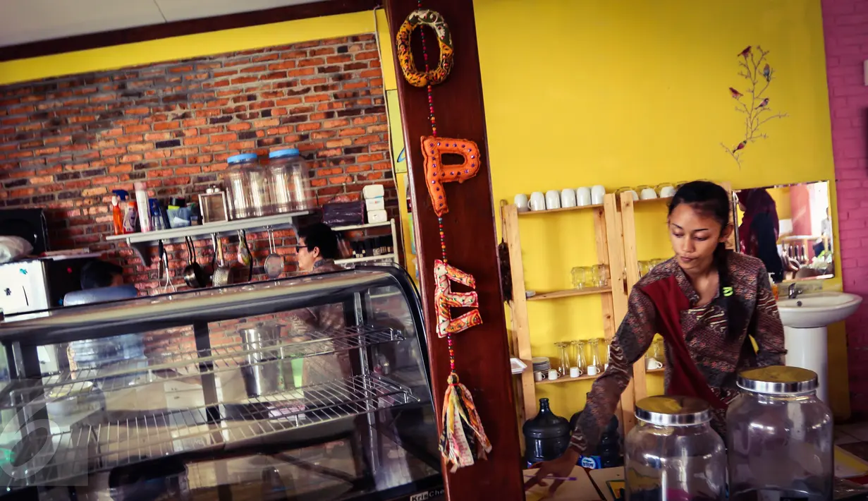 Pramusaji, yang merupakan penyandang tunarungu, ketika menyajikan pesanan  pelanggan di kafe Finger Talk, Pamulang, Tangsel, Sabtu (20/2). Dengan ramah dan cekatan, sejumlah penyandang tunarungu akan menjamu para pengunjung. (Liputan6.com/Fery Pradolo)