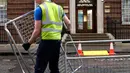 Pekerja memasang pagar pembatas di seberang area Lingdo Wing, Rumah Sakit St. Mary di Paddington, London, Senin (9/4). Rumah sakit tempat Kate Middleton direncanakan akan melahirkan mulai meningkatkan aktivitas pengamanannya. (AP/Kirsty Wigglesworth)