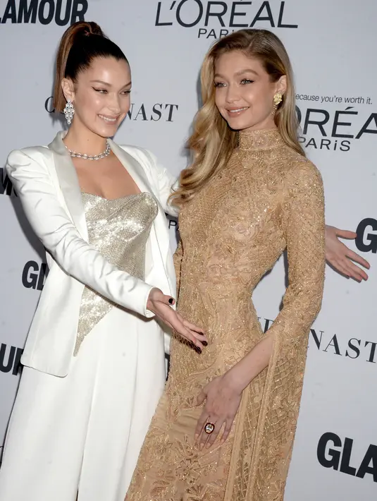 Gigi dan Bella Hadid memeriahkan karpet merah acara tahunan Glamour Women Of The Year 2017 di Brooklyn, New York, Senin (13/11). Bella juga tampil mengesankan dengan atasan warna perak yang memamerkan sedikit keseksiannya. (Evan Agostini/Invision/AP)