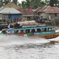 Warga menggunakan perahu motor sebagai transportasi alternatif dari Kota Palembang menuju Ogan Komering Ilir (OKI) di Sungai Baung, Sumsel, (24/30). Dari Kota Palembang menuju OKI hanya menghabiskan waktu 2 jam. (Liputan6.com/Gempur M Surya)