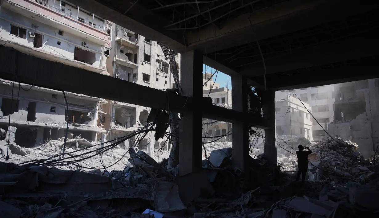 Seorang warga memeriksa sebuah bangunan yang rusak akibat serangan Israel di kota pelabuhan Tyre, Lebanon Selatan, Kamis 18 Juni 2026. (AP Photo/Hassan Ammar)