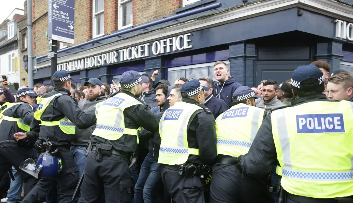 Petugas kepolisian saat terlibat bentrok dengan suporter Millwall sebelum pertandingan perempat final Piala FA antara Tottenham Hotspur melawan Millwall di White Hart Lane, London, (12/3). (Yui Mok//PA via AP)
