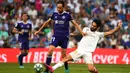 Gelandang Real Madrid, Isco, menekel gelandang Valladolid, Michel, pada laga La Liga di Stadion Santiago Bernabeu, Madrid, Sabtu (24/8). Kedua klub bermain imbang 1-1. (AFP/Gabriel Bouys)