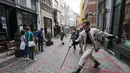 Seorang seniman memainkan permainan dalam garis persegi (grid game) dengan pelintas di Royal Gallery of Saint Hubert di Brussel, Belgia (15/7/2020). Permainan ini dirancang agar orang menghormati aturan jaga jarak sosial selama pandemi COVID-19. (Xinhua/Zheng Huansong)