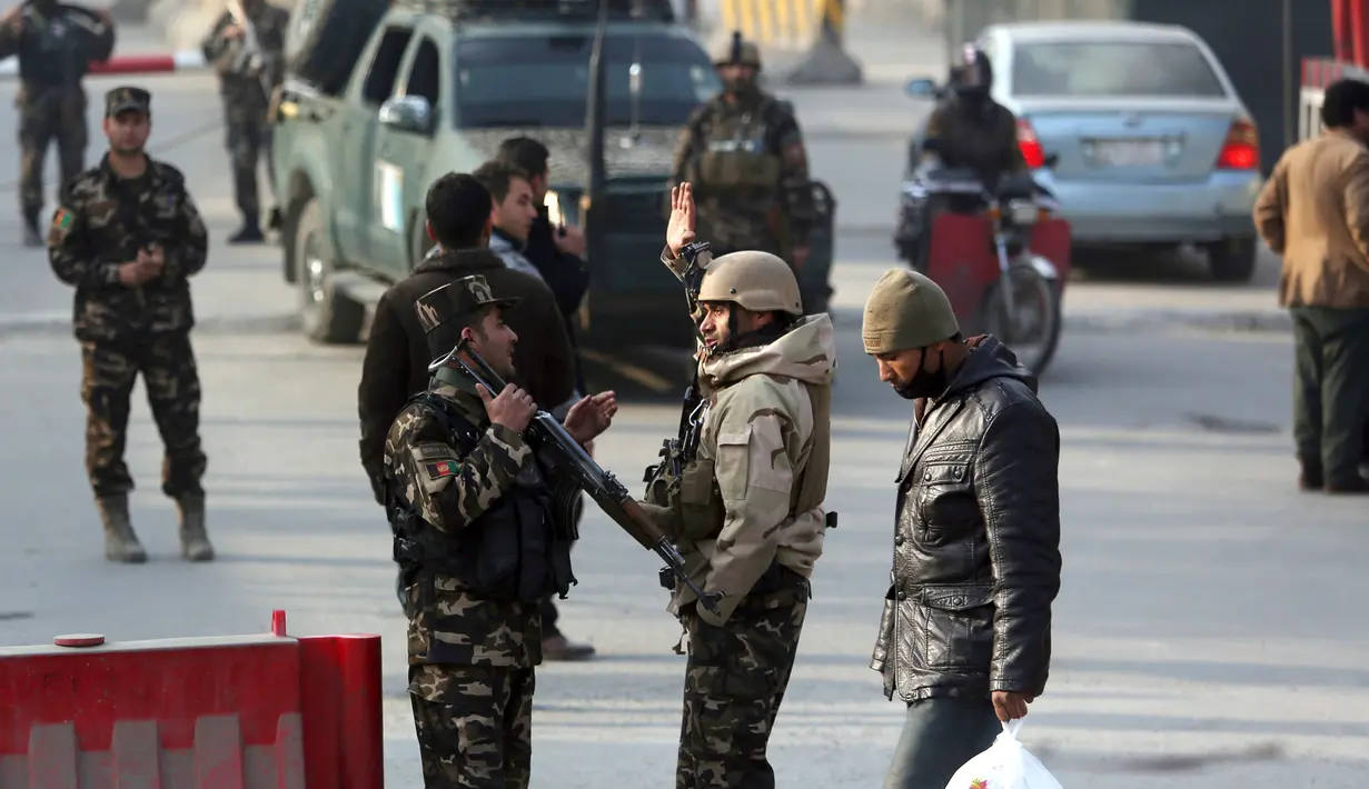 Personel keamanan Afghanistan berjaga di dekat lokasi serangan bunuh diri di Kabul, Afghanistan (25/12). Menurut sejumlah pejabat, peristiwa yang terjadi bertepatan dengan hari raya Natal itu menewaskan enam warga sipil. (AP Photo / Rahmat Gul)