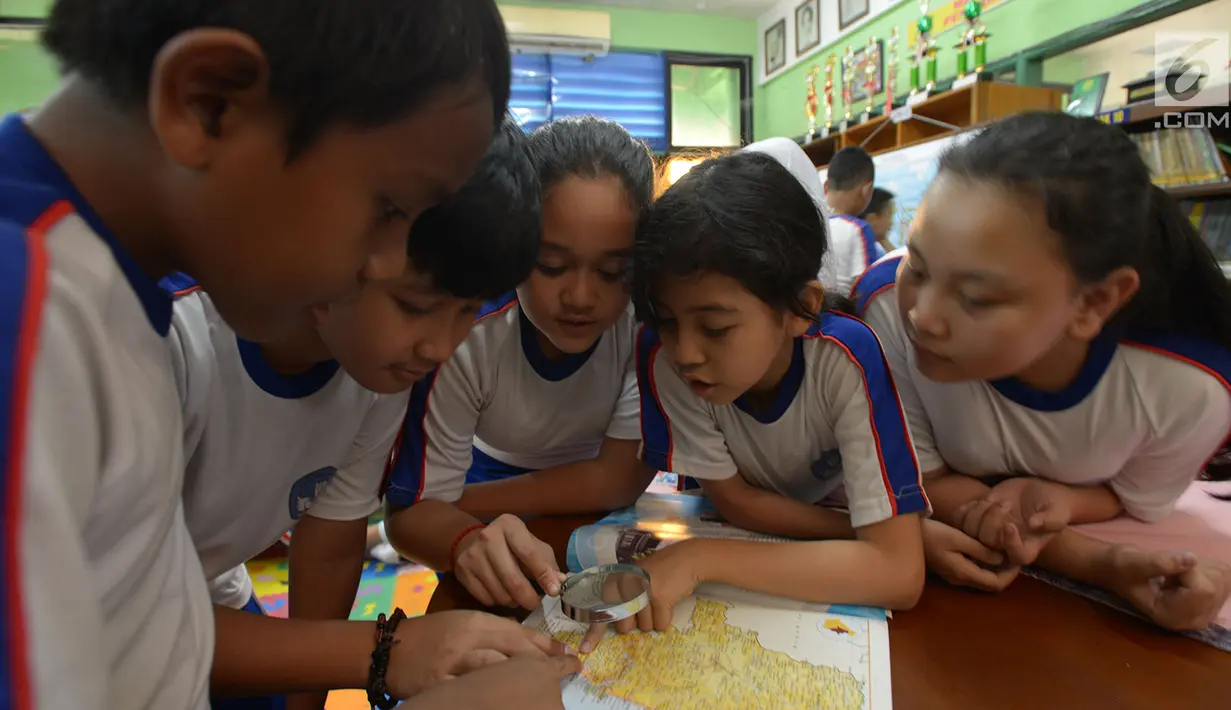 Sejumlah siswa mencari lokasi calon ibu kota baru pada peta saat kegiatan belajar bertema wawasan Nusantara di SDN Menteng 02, Jakarta, Selasa (27/8/2019). Kegiatan belajar wawasan Nusantara itu memberitahukan lokasi pemindahan ibu kota RI dari Jakarta ke Kalimantan Timur.(merdeka.com/Imam Buhori)