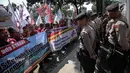Sejumlah petugas kepolisian berjaga saat aksi unjuk rasa di depan kantor Kementerian BUMN, Jakarta, Senin (31/7). Dalam aksinya mereka  menuntut evaluasi Kementerian BUMN terkait adanya potensi kerugian negara. (Liputan6.com/Faizal Fanani)