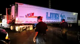 Sebuah kontainer truk trailer berisi lebih dari 100 dipindahkan dari Guadalajara menuju Jalisco di Meksiko, Senin (17/9). Mayat-mayat tersebut tidak bisa diserahkan kepada keluarganya karena belum diketahui identitasnya. (AFP/Ulises Ruiz)