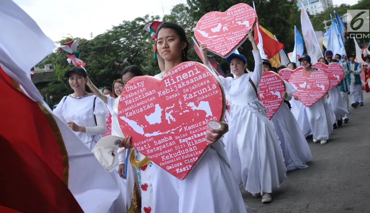 Sejumlah umat Kristiani membawa lambang hati saat kirab perayaan Paskah di sekitar Jalan Medan Merdeka Selatan, Jakarta, Minggu (4/1). Kirab dimulai dari Bundaran Hotel Indonesia dan berakhir di gereja Immanuel Jakarta. (Liputan6.com/Helmi Fithriansyah)