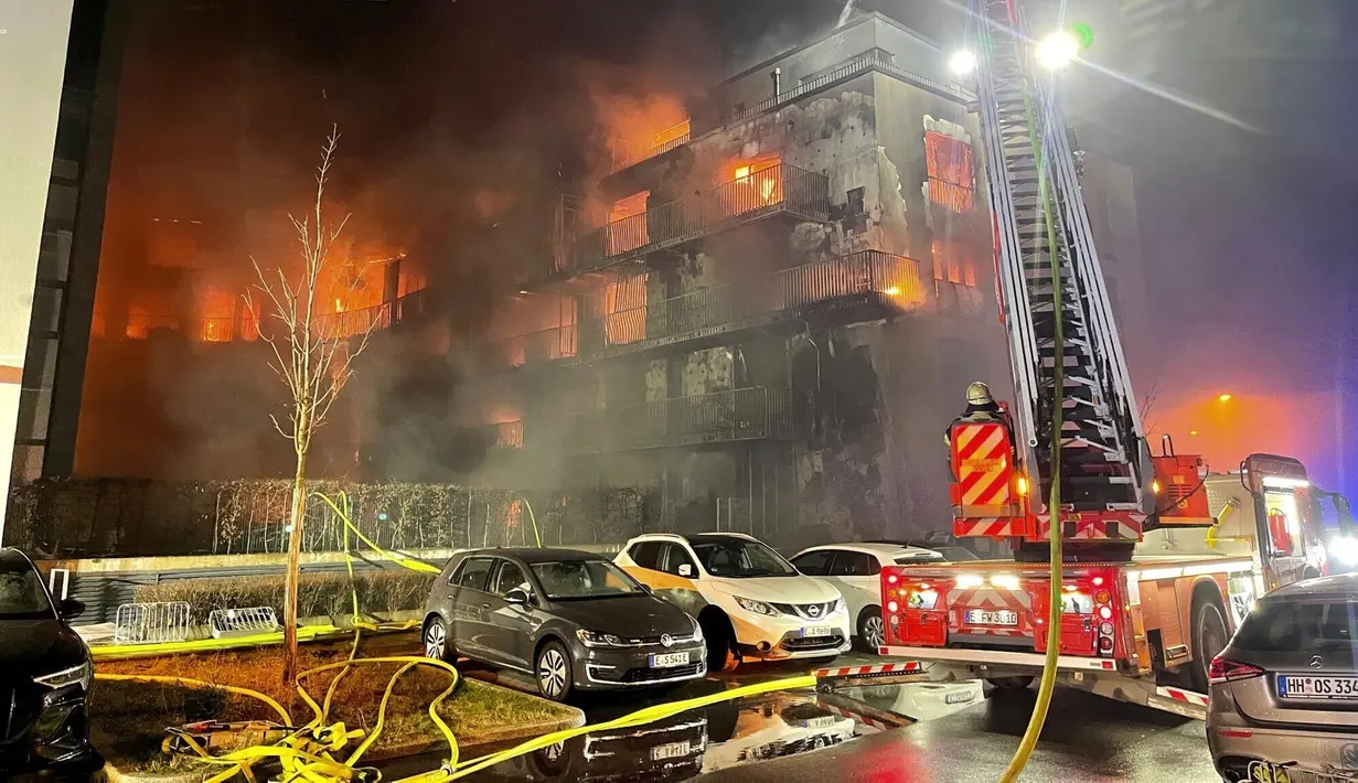 Petugas pemadam kebakaran memadamkan api di kompleks apartemen di Essen Jerman, Senin (21/2/2022). Sedikitnya tiga orang terluka dalam kebakaran besar di kompleks apartemen itu. (Christoph Reichwein/dpa vi aAP)