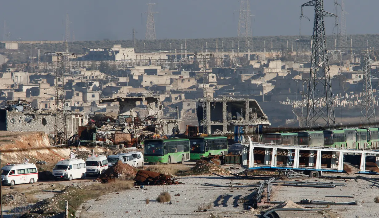Iring-iringan ambulans dan bus yang mengevakuasi ribuan warga meninggalkan wilayah yang dikuasai pemberontak di Aleppo, Suriah, Kamis (15/12). Bus dan ambulans digunakan untuk mengevakuasi ribuan warga dari wilayah konflik tersebut (REUTERS/Omar Sanadiki)