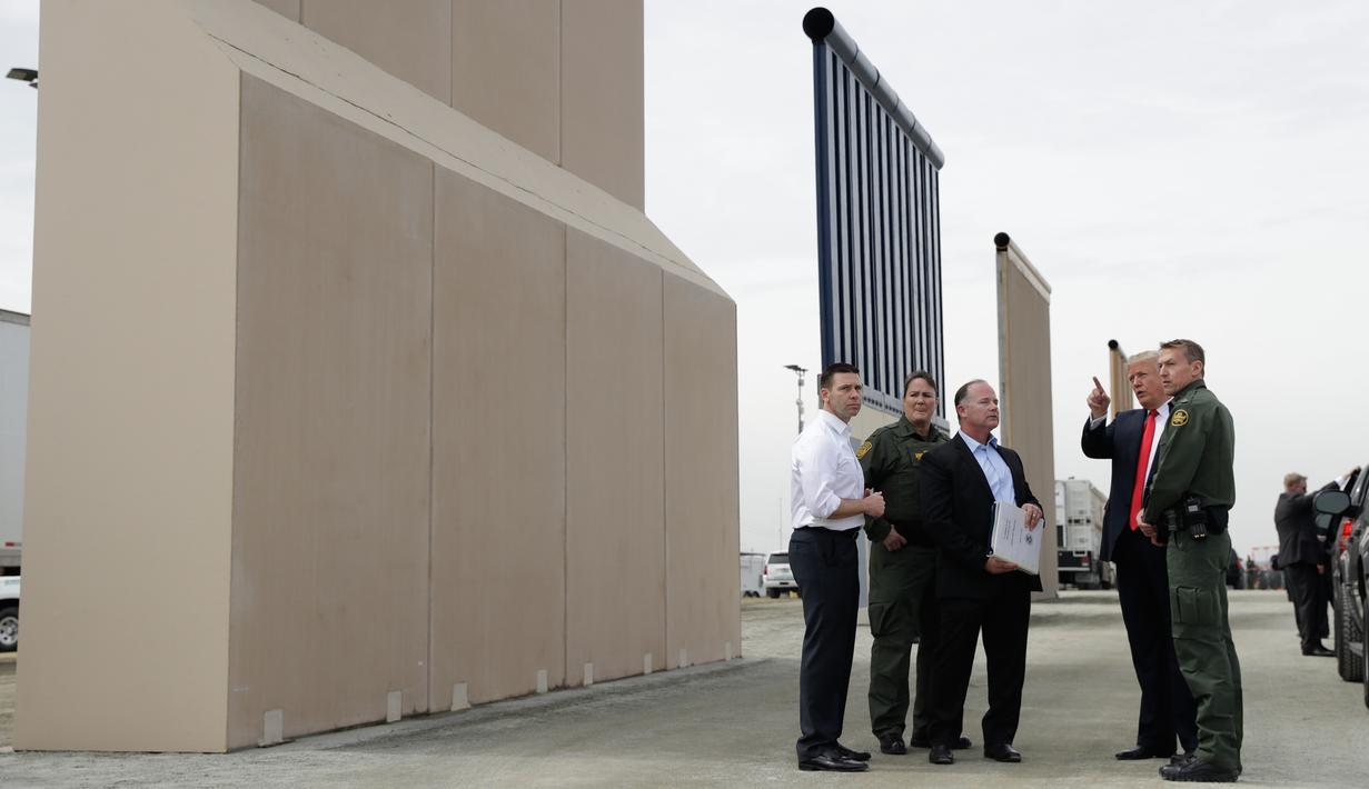 Presiden AS, Donald Trump meninjau prototipe tembok perbatasan AS dan Meksiko yang kontroversial di San Diego, Selasa (13/3). Ada sekitar delapan purwarupa panel tembok yang akan ditinjau Trump di perbatasan San Diego-Tijuana. (AP/Evan Vucci)