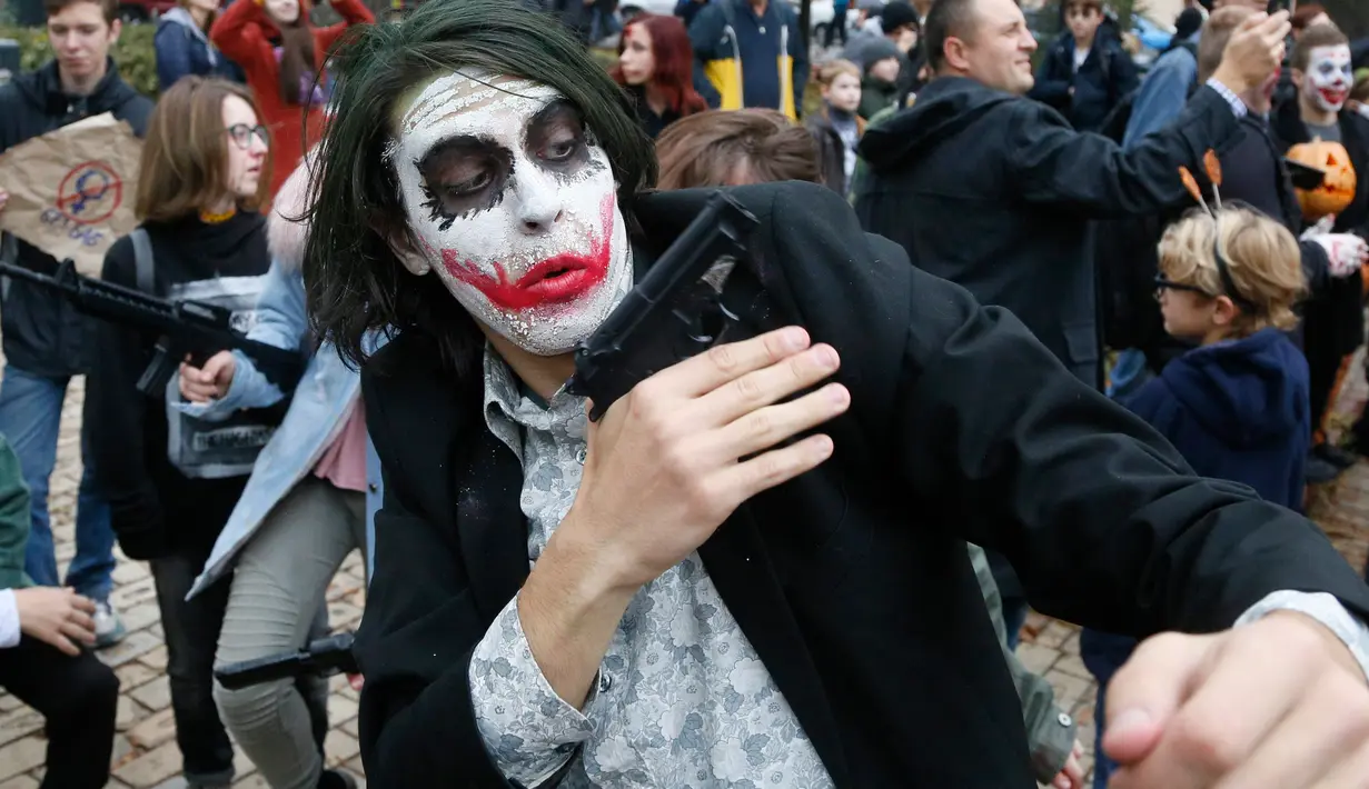 Seorang pria berpose dengan dandanan menyerupai zombie ketika berpartisipasi dalam 'Zombie Walk' di pusat Kota Kiev, Ukraina, 26 Oktober 2019. Menjelang perayaan Halloween pada 31 Oktober mendatang, warga di beberapa belahan dunia sudah mulai melakukan acara bertema horor. (AP/Efrem Lukatsky)