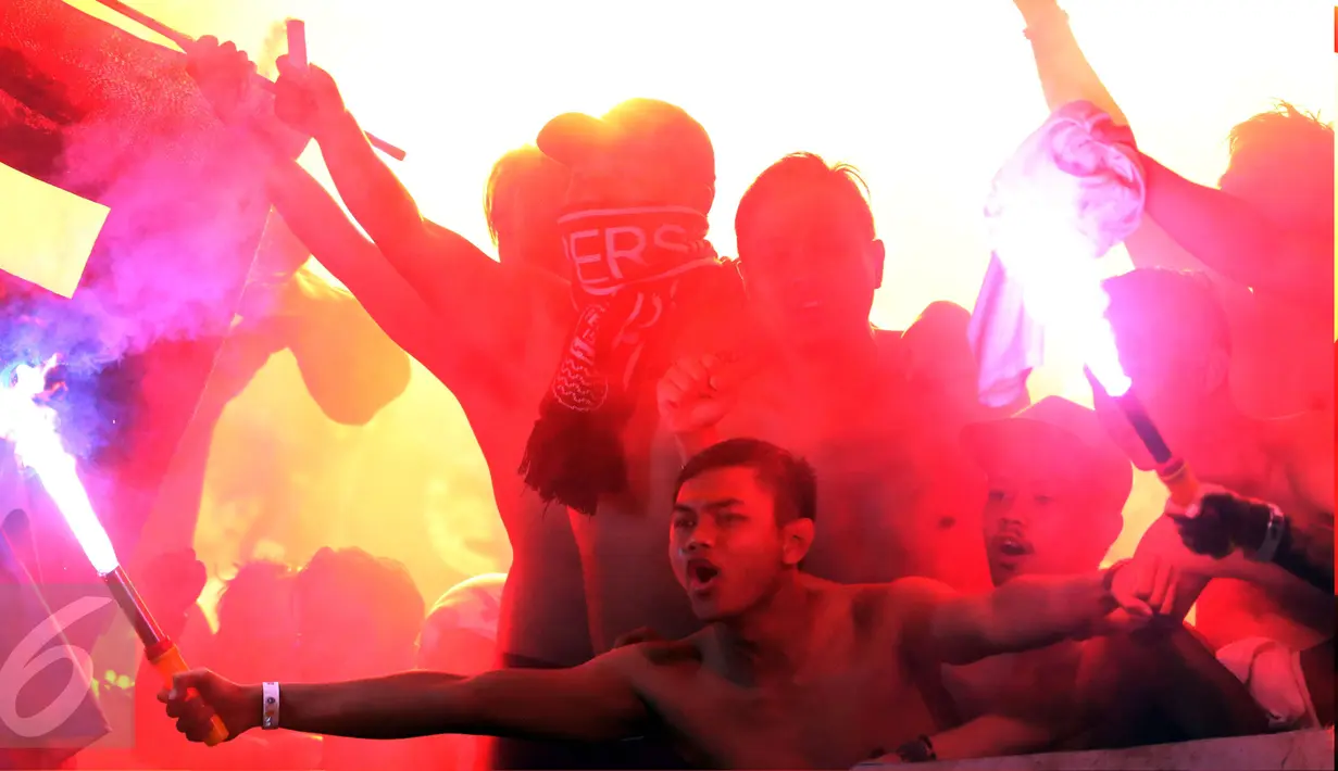 Suporter tim Maung Bandung bersorak sambil menyalakan suar usai menyaksikan laga Persib melawan Mitra Kukar FC di babak 8 besar Piala Presiden 2017 di Stadion Manahan, Solo, Sabtu (25/2). Persib lolos ke semifinal. (Liputan6.com/Helmi Fithriansyah) 