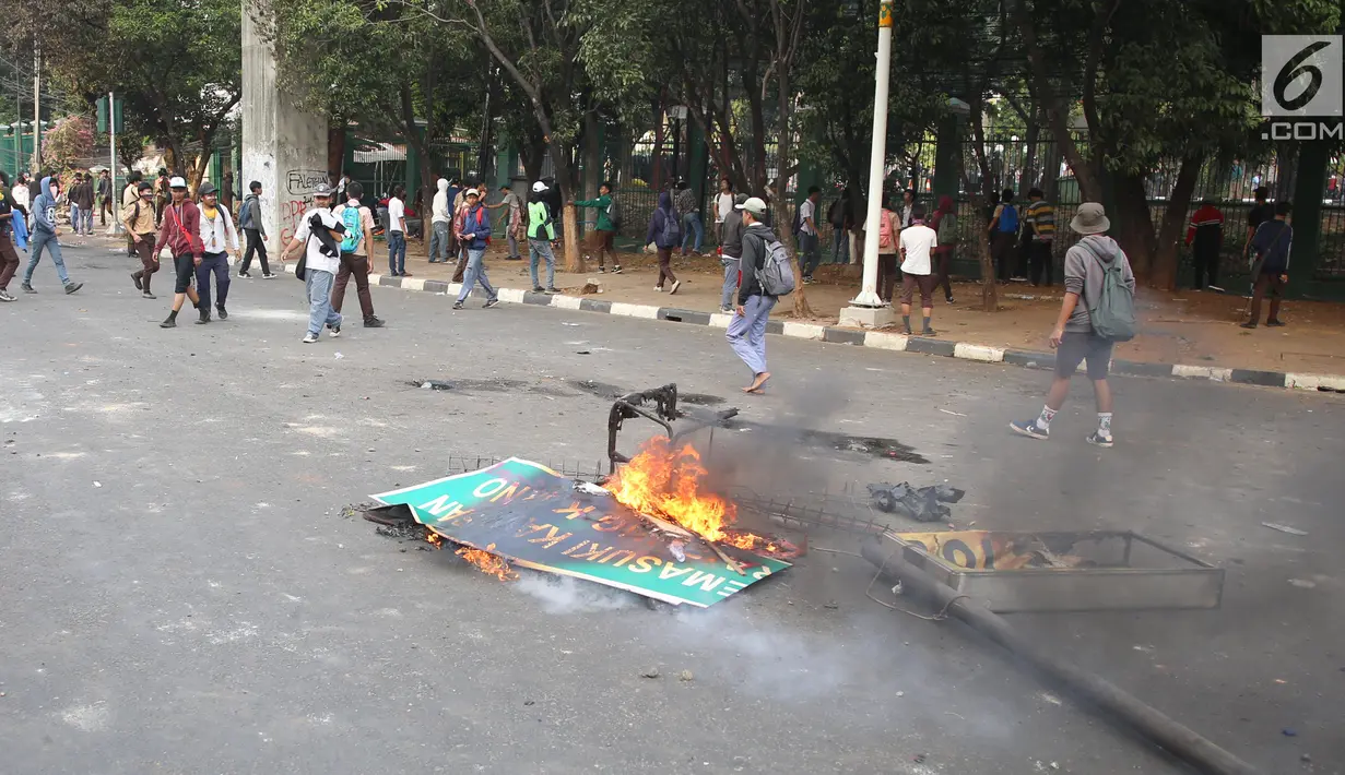 Rambu lalu lintas terbakar saat pelajar berdemonstrasi di belakang Gedung DPR, Palmerah, Jakarta, Rabu (25/9/2019). Selain membakar sejumlah benda, para pelajar juga melempari Gedung DPR dengan batu. (Liputan6.com/Angga Yuniar)