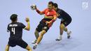 Pemain bola tangan Indonesia, Dupa Gilang Pratama W (tengah) mencoba lolos dari kawalan pemain Malaysia pada penyisihan grup 3 bola tangan Asian Games 2018 di GOR PP POPKI, Jakarta, Minggu (26/8). Indonesia unggul 31-22. (Liputan6.com/Helmi Fithriansyah)