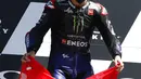 Pembalap Yamaha Fabio Quartararo memegang bendera Swiss untuk menghormati pembalap Swiss Jason Dupasquier (19) yang tewas dalam kecelakaan saat upacara podium di akhir MotoGP Mugello di Sirkuit Mugello, Scarperia, Italia, Minggu (30/5/2021). (AP Photo/Antonio Calanni)