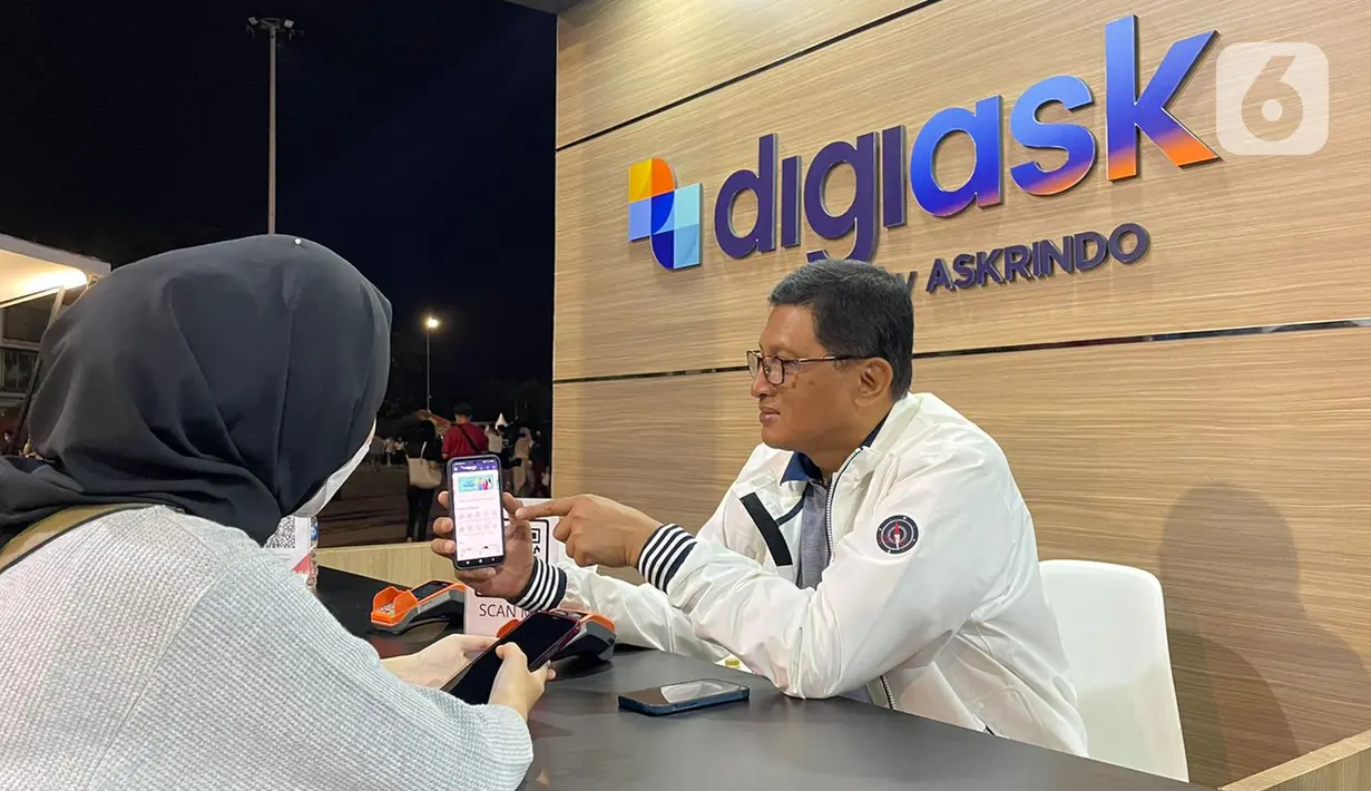 Direktur Utama Askrindo, Priyastomo melayani pengunjung saat transaksi pembelian Asuransi Kecelakaan Diri Askrindo pada aplikasi digiask di booth digiAsk Askrindo di gelaran Java Jazz Festival 2022, Jakarta (29/05/2022). Aplikasi digiAsk dari Askrindo memberikan proteksi asuransi kecelakaan diri untuk seluruh penonton, artis dan crew saat gelaran Java Jazz Festival 2022. (Liputan6.com/HO/Askrindo)