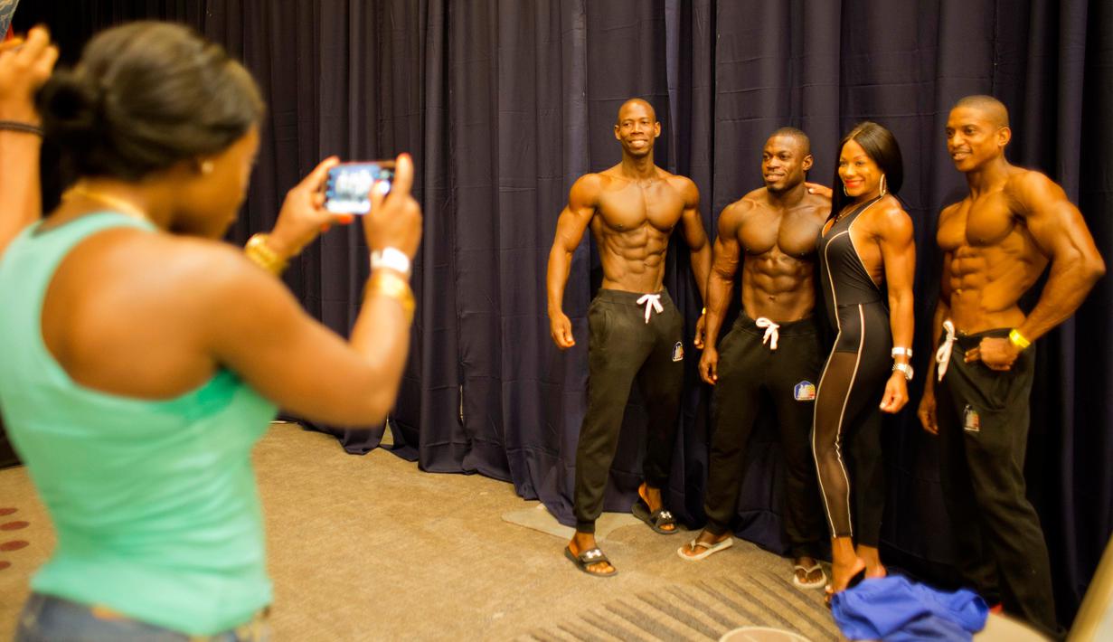 Spely Laventure (ketiga dari kanan) berfoto bersama penggemar dan binaragawan asal Haiti lainnya di Port-au-Prince, Haiti, Minggu (23/7). Lebih dari dua lusin pria dan satu wanita ikut dalam kompetisi ini. (AP/Dieu Nalio Chery)
