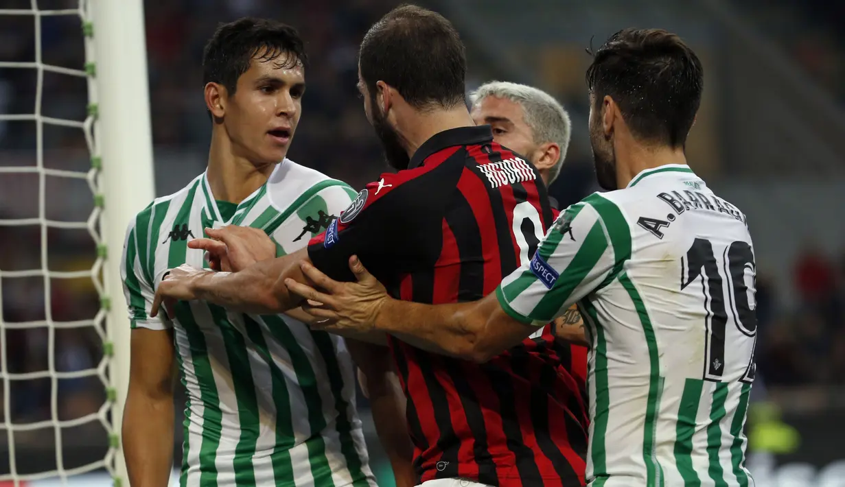 Striker AC Milan, Gonzalo Higuain, bersitegang dengan pemain Real Betis, Aissa Mandi, pada laga Liga Europa di Stadion San Siro, Kamis (25/10/2018). AC Milan takluk 1-2 dari Real Betis. (AP/Antonio Calanni)