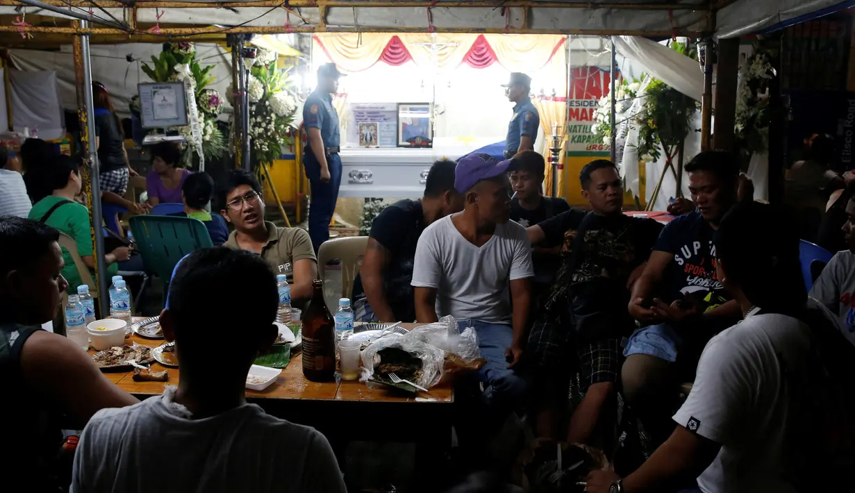 Para kerabat berkumpul melayat Rancel Cruz petugas kepolisian yang mati di tembak pecandu narkoba di Manila, Filipina, (19/10). Sebanyak 1.900 orang tewas akibat perang narkoba di Filipina. (REUTERS/Erik De Castro)