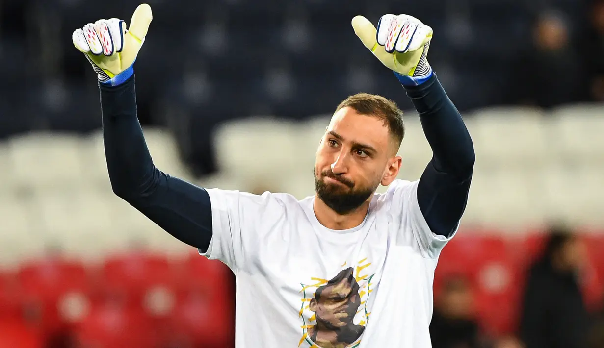 Kiper Paris Saint-Germain (PSG) Gianluigi Donnarumma memberi isyarat saat mengenakan kaos dengan potret mendiang legenda sepak bola Brasil Pele sebelum lanjutan Liga Prancis 2022/2023 melawan Angers di Parc des Princes, Kamis (12/1/2023) dini hari WIB. Para pemain PSG memberikan tribute spesial untuk Edson Arantes do Nascimento atau lebih dikenal sebagai Pele. (Bertrand GUAY / AFP)