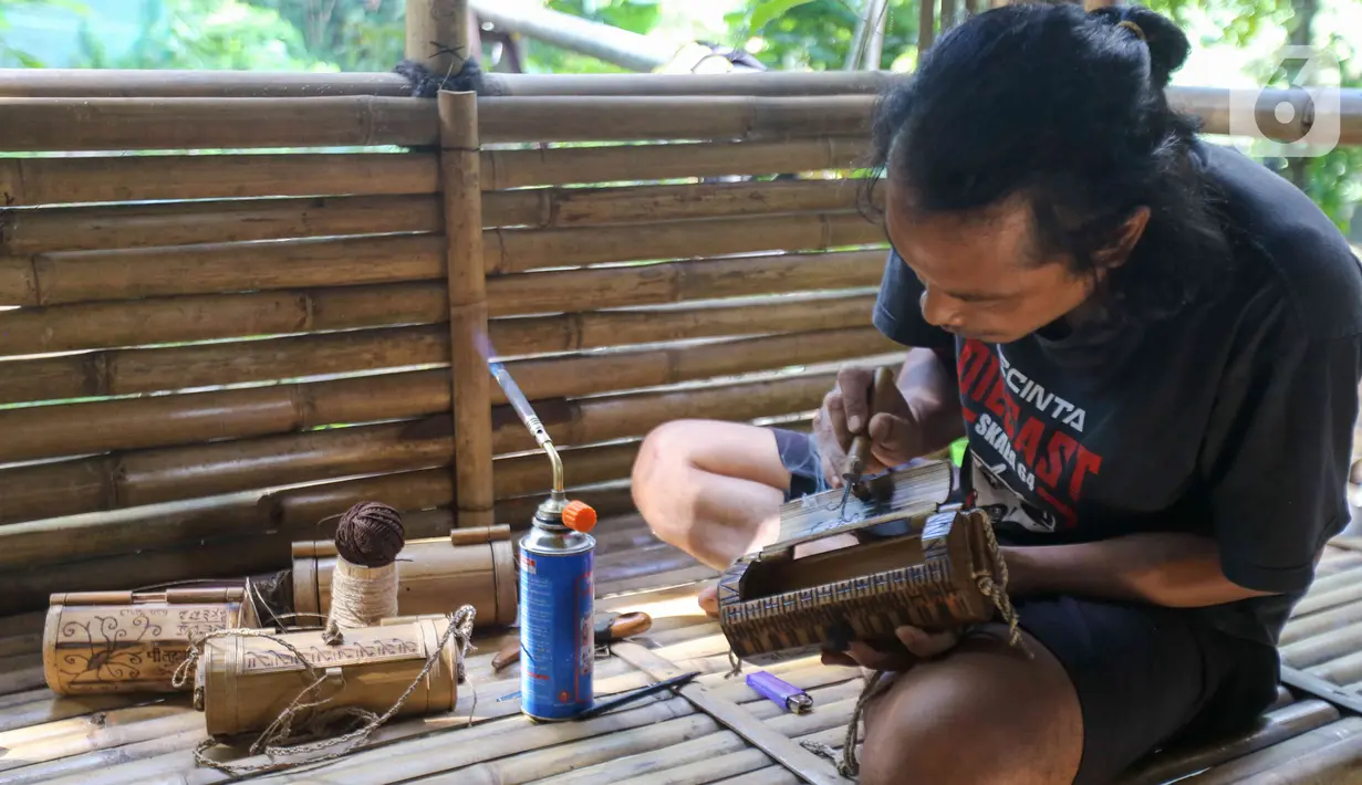 Perajin membuat kerajinan tas dari limbah bambu di Grand Depok City, Depok, Jawa Barat, Kamis (2/6/2022). Kerajinan berbahan dasar limbah bambu dijual dengan harga Rp 100 ribu - Rp 300 ribu per buah tergantung tingkat kesulitan. (Liputan6.com/Herman Zakharia)