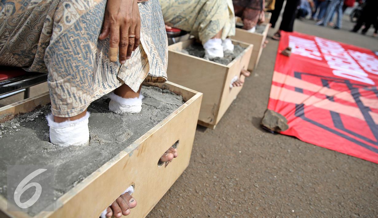 Aksi petani mengecor kakinya di depan Istana Negara, Jakarta, Selasa (13/4). Menurut mereka, pembangunan  pabrik semen tersebut dapat mengancam kehidupan petani dan masyarakat. (Liputan6.com/Faizal Fanani)