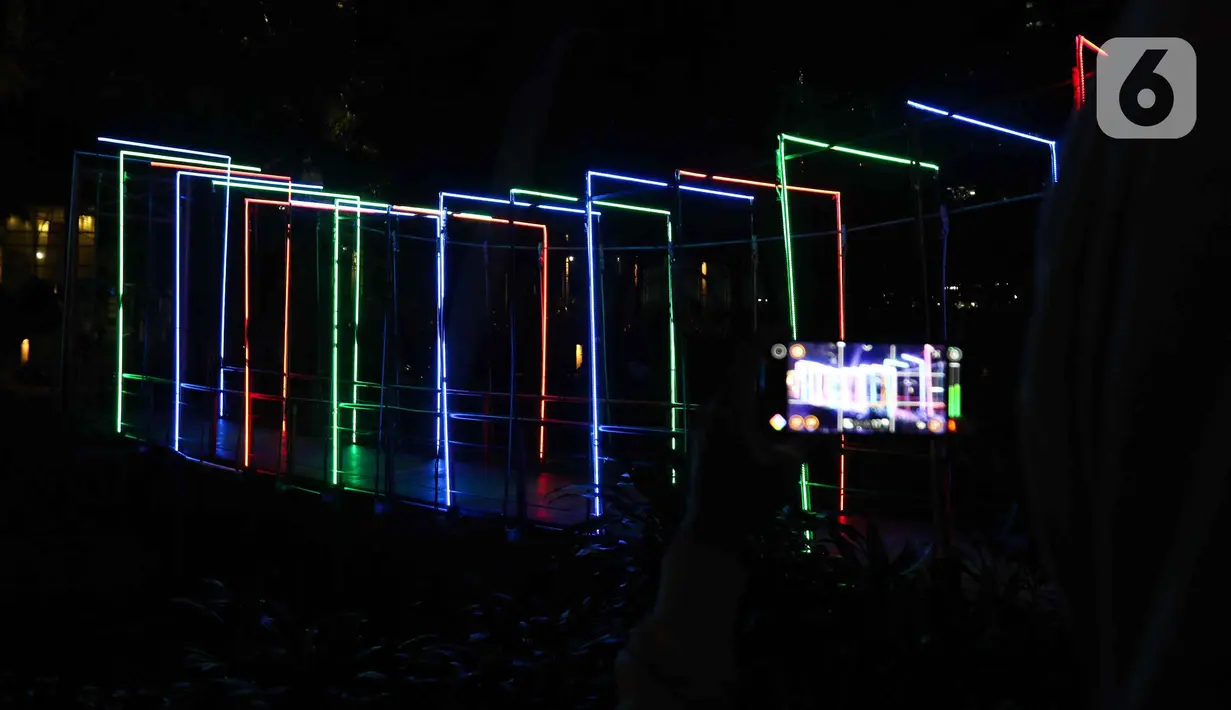 Warga saat memotret Jakarta Lights Festival di Taman Sumenep, Jakarta, Jumat (23/12/2022). Pemprov DKI Jakarta menggelar acara Jakarta Lights Festival sebagai rangkaian perayaan Natal dan Tahun Baru (Nataru) 2023. (Liputan6.com/Herman Zakharia)