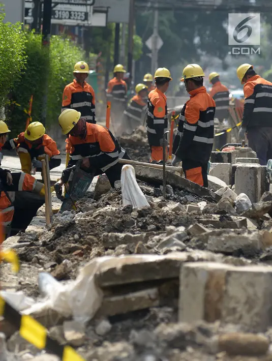 Pekerja membongkar trotoar lama di Jalan Cikini Raya, Taman Ismail Marzuki (TIM), Jakarta, Selasa (18/6/2019). Revitalisasi trotoar TIM hingga Jalan Diponegoro dilakukan agar ramah bagi pejalan kaki dan penyandang disabilitas. (merdeka.com/Imam Buhori)